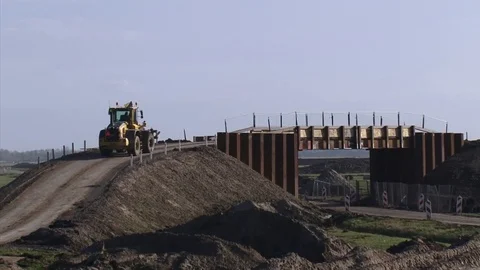 Tractor, construction vehicle across a temporary bridge with retaining walls Stock Footage 82648293