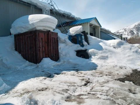 Tractor, container, front door covered with snow after snowfall in winter on Stock Photos