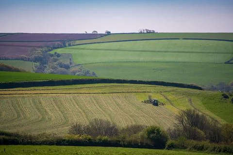 Tractor in Cornish farmland with patchwork fields and rolling hills 库存照片