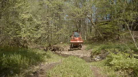 Tractor crossing stream in spring farm equipment 4k Stock Footage 109023436