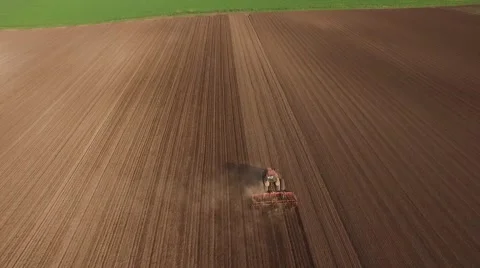 Tractor cultivating arable land for seeding crops, aerial view Stock Footage 62461663