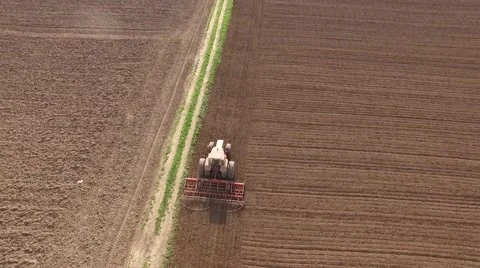 Tractor cultivating arable land for seeding crops, aerial view Stock Footage 62467125