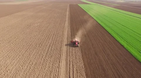 Tractor cultivating arable land for seeding crops, aerial view Vidéo 62467797