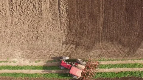 Tractor cultivating arable land for seeding crops, aerial view Stock Footage 62468053