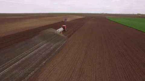 Tractor cultivating arable land for seeding crops, aerial view Stock Footage 62469877