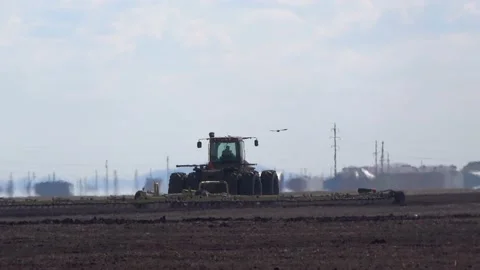 Tractor cultivating field at spring. Spring works. Tractor in the field Stock Footage 153974668