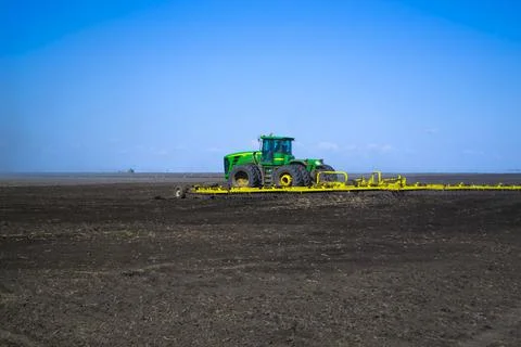 Tractor cultivating field at spring. Spring works. Tractor in the field Stock Photos