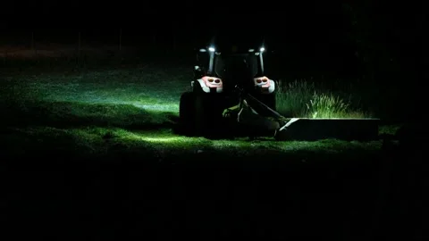 A tractor cuts the grass in the night Видео 134163461