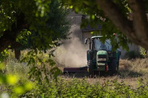 A tractor cutting grass in summer Stock Photos
