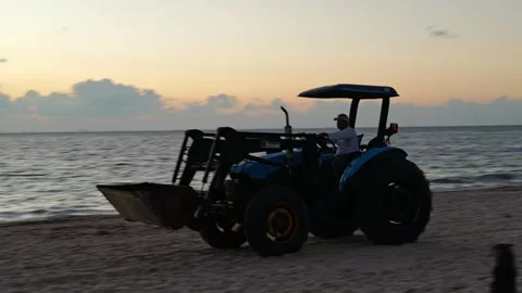 Tractor at dawn driving on the beach to collect seaweed in Yucatan Mexico Vídeos de archivo 345907056