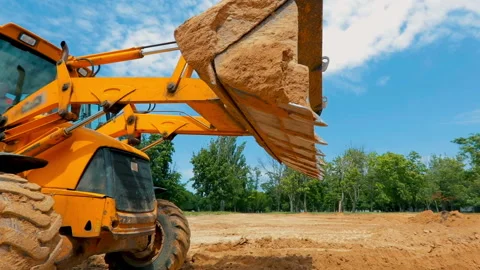 A tractor digs a hole at a construction site. Working process at a construction Video stock 192316341