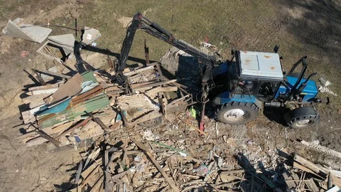  tractor disassembles the rubble after the destruction of the house. Stock Footage 127957746