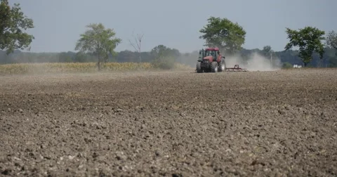 Tractor Distantly is Plowing The Field Tractor is Approaching Flying Dust Stock Footage 53609607