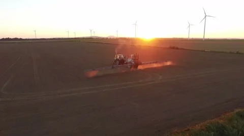 Tractor doing field sprayer at sunset Stock Footage 67232320