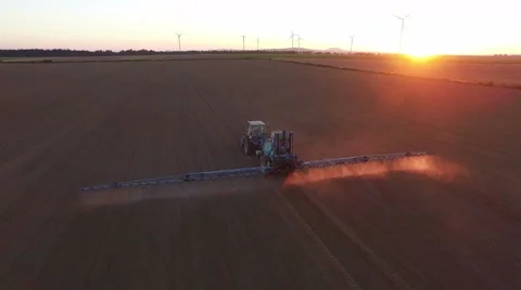 Tractor doing field sprayer at sunset Stock Footage 67232371