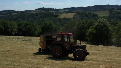 Tractor doing a U-turn around a round baller Video stock 144541048