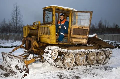 The tractor driver cleans snow Stock Photos