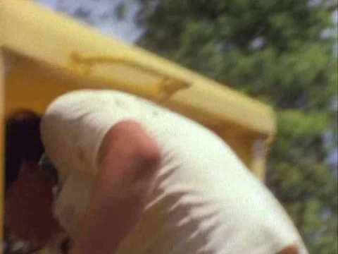 Tractor driver making adjustments while he smokes a cigarette Stock Footage 79950258