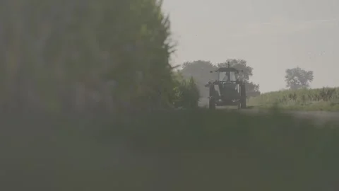 Tractor drives down farm road FLAT Stock Footage 283503063