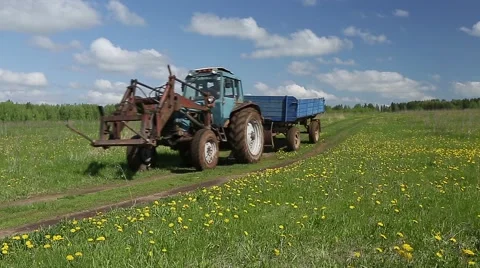 Tractor drives on the road through the field 스톡 동영상 57358656