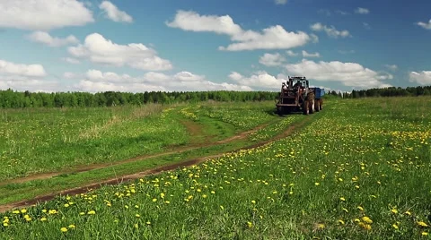 Tractor drives on the road through the field Stock Footage 57359056