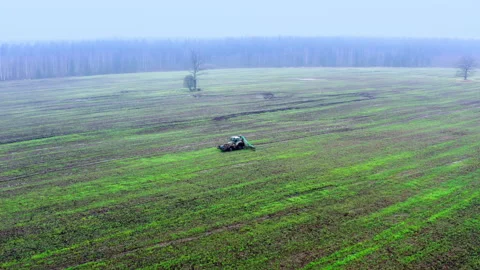 The tractor drives through the field and released agricultural fertilizer Stock Footage 219729632