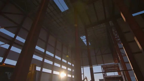Tractor drives through a huge and tall workshop under construction Stock Footage 161957093