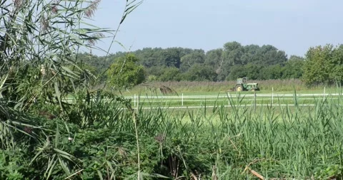 Tractor driving across a plain green grass field Vídeos de archivo 160631458