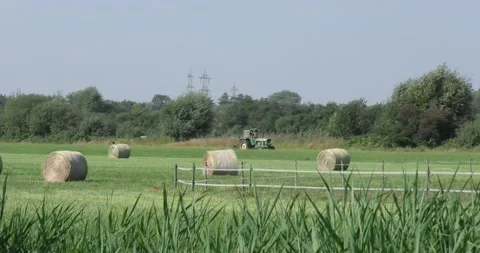 Tractor driving across a plain green grass field Vídeos de archivo 160631742