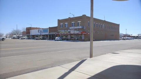 Tractor driving down small rural town road Stock Footage 104888527