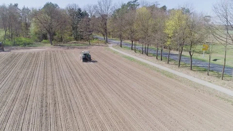 Tractor driving ove empty soil aerial view Stock Footage 107975084