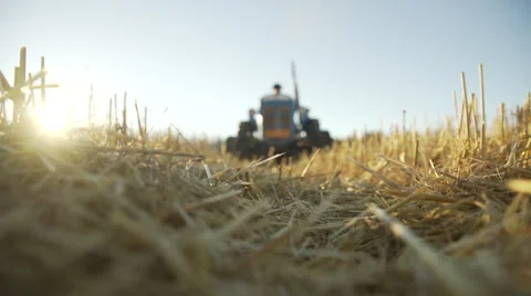 Tractor driving over the camera while the sun sets 動画素材 61405078
