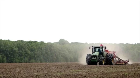 The tractor is driving through the field. plows the land in summer. Stock Footage 84332870
