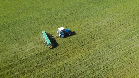 Tractor drops solid fertilizers on field with chemicals and herbicides for Stock Footage 126581531
