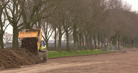Tractor dumper unloading sand or clay in construction area Stock Footage 106433367