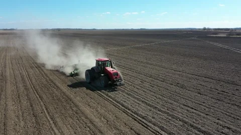 Tractor in the dust working in the field. Farmer seeding crops at field Stock-Footage 128276881