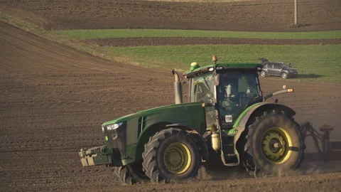 Tractor in the dust working in the field. Vidéo 132089011