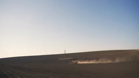 Tractor in the dust working in the field.  Vidéo 132089458
