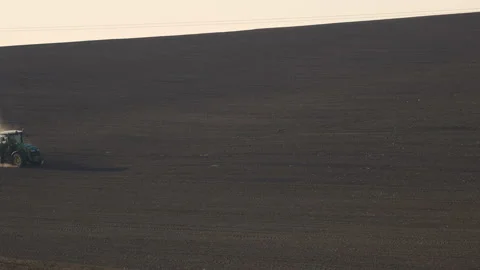 Tractor in the dust working in the field.  Vidéo 132089950