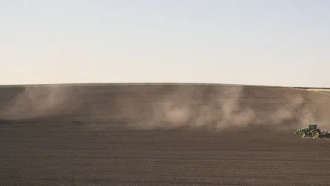 Tractor in the dust working in the field. Vidéo 132090518