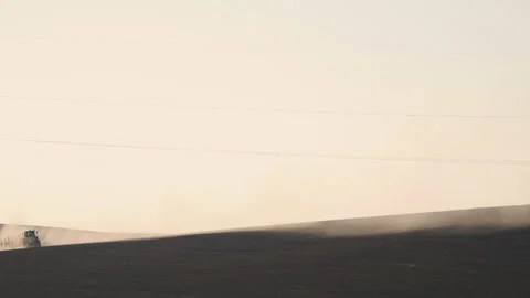 Tractor in the dust working in the field. Vidéo 132090624