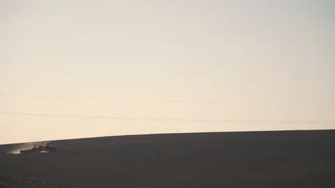 Tractor in the dust working in the field. Vidéo 132090667