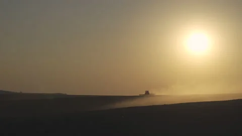 Tractor in the dust working in the field at sunset. Vídeo Stock 132104610