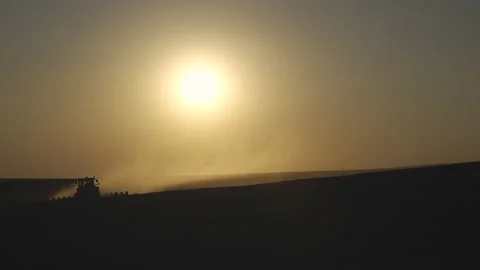Tractor in the dust working in the field at sunset. Vidéo 132104932
