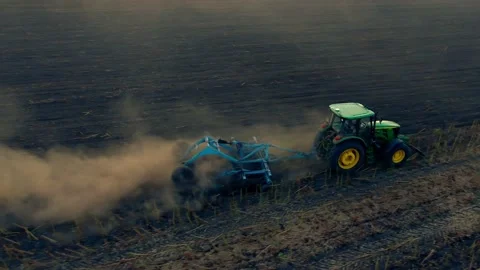 Tractor in the dust working in the field. Tractor cultivating farming land with Stock Footage 138897859