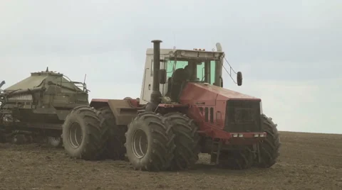 Tractor with eight wheels and a trailed hopper for grain on field Stock Footage 64619932