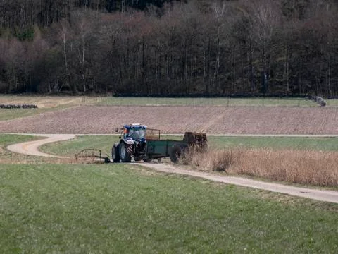 A tractor fertilize the fields Stock Photos