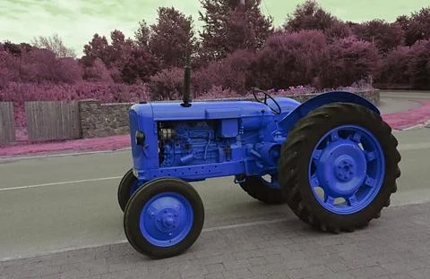 Tractor in the field in blue Stock Photos