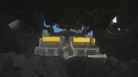 Tractor in a field with a corn planter drives straight towards the camera. View  Stock Footage 221721799