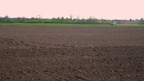 The tractor on the field cultivates the soil. Selective focus. Stock Footage 241926038